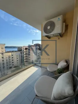 Namješten balkon sa staklenom ogradom i pogledom na more i grad. - image 14