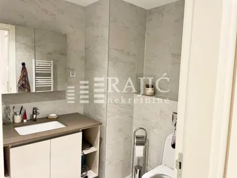 Modernly equipped bathroom with a washbasin and marble tiles. - image 6
