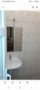 Manje kupatilo sa umivaonikom, ogledalom i pločicama na zidovima. - image 7