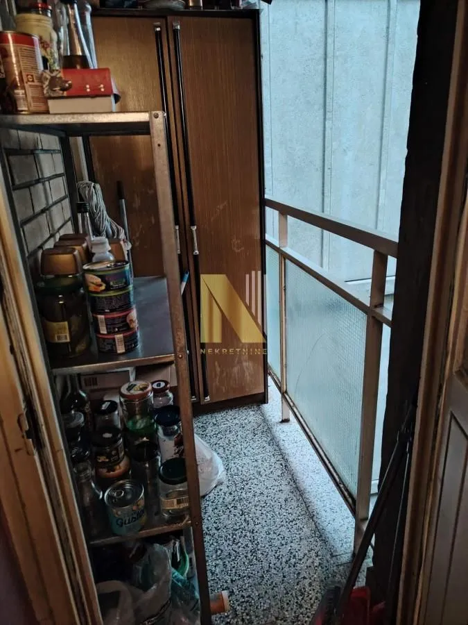 Manji zastakljeni balkon sa policama za odlaganje hrane i ormarom.