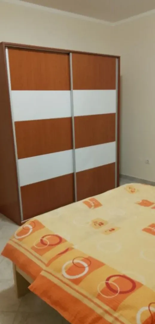 Spavaća soba sa krevetom i velikim drvenim ormarom.