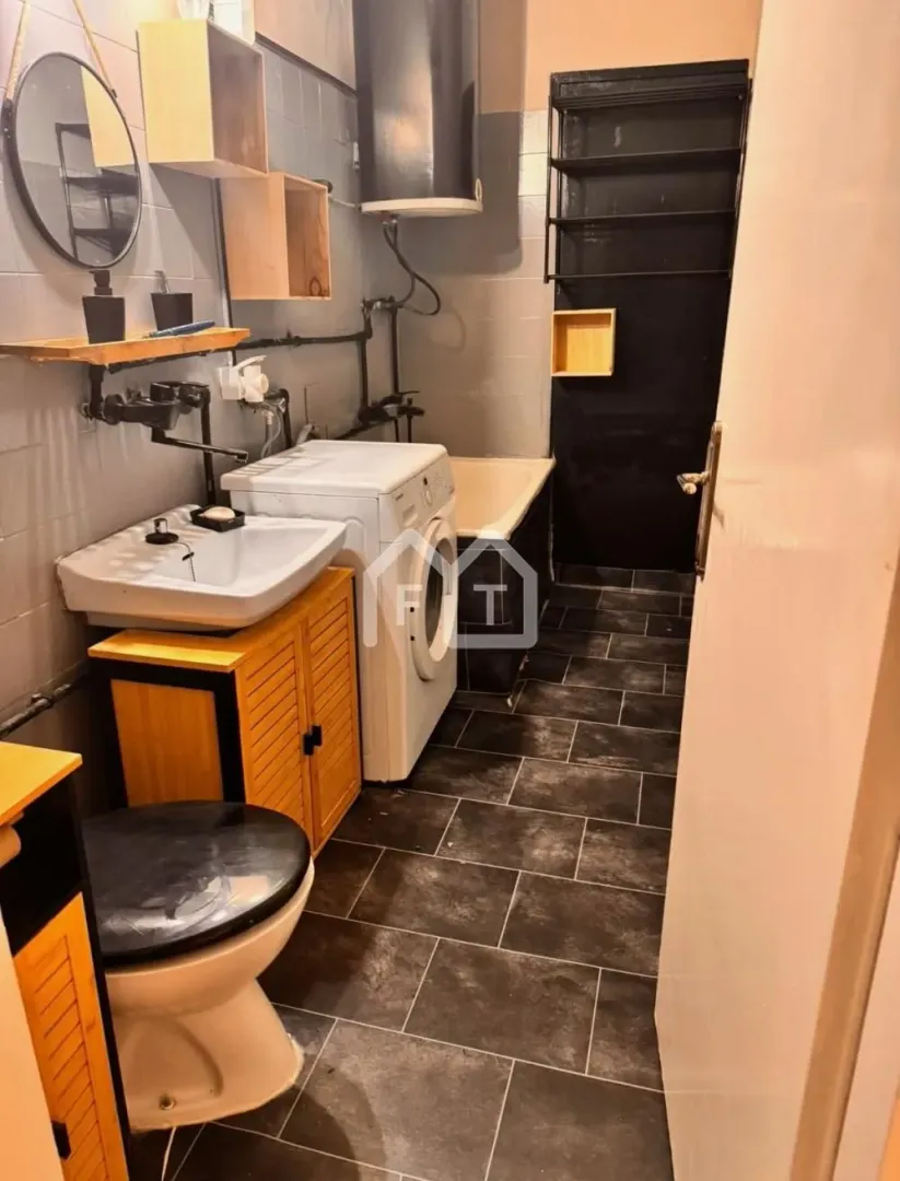 Small bathroom with a bathtub, washbasin, toilet, and washing machine.