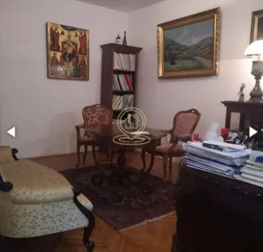 Living room furnished with classic furniture, bookshelves, and paintings on the wall. - image 15