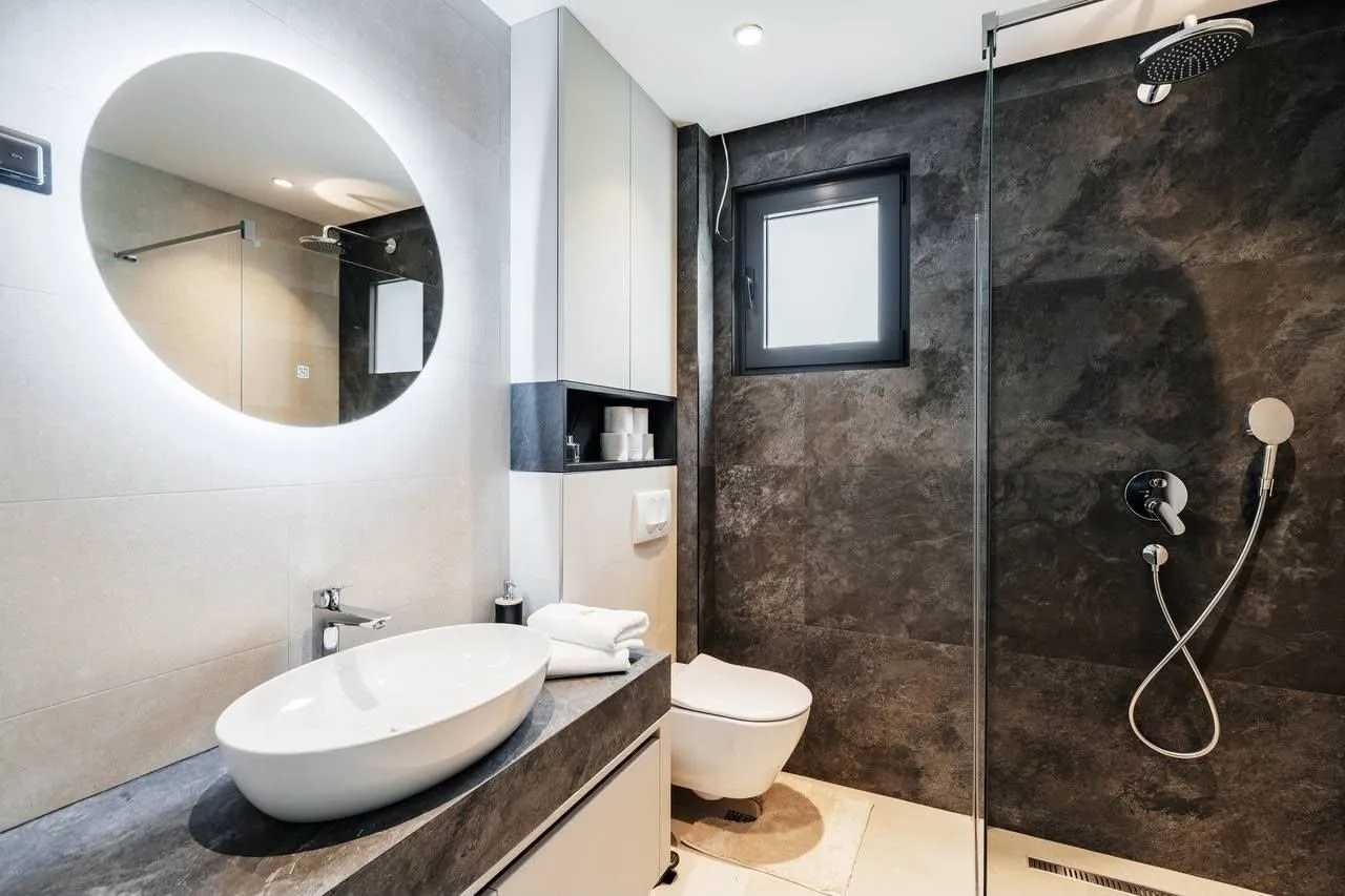 Modern bathroom equipped with a walk-in shower and a washbasin.