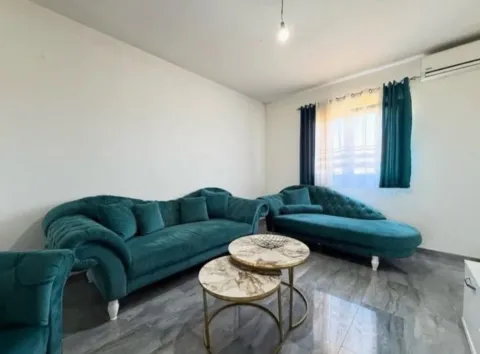 Living room with green sofas and round coffee tables. - image 12