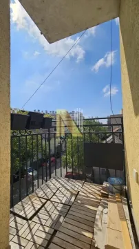 Manji balkon sa drvenom podlogom i pogledom na naselje. - image 8