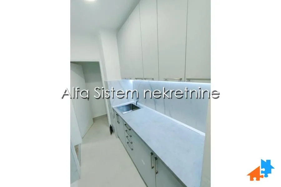 Small kitchen with white cabinets and a sink.