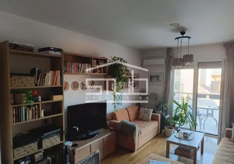 Living room with a sofa, television, bookshelves, and access to the terrace. - image 12