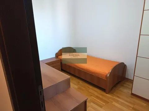 Manja spavaća soba sa krevetom i drvenim nameštajem. - image 3