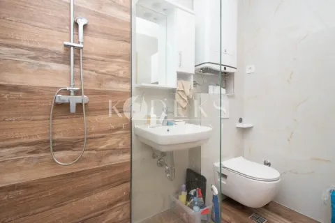 Compact bathroom equipped with a shower cabin, washbasin, and toilet. - image 8