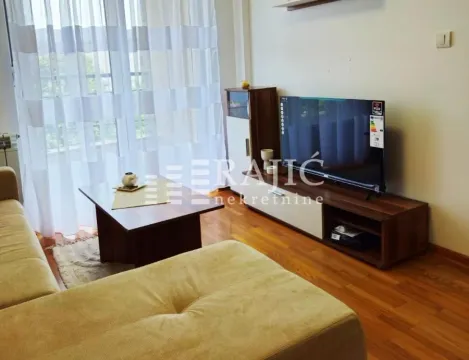 Living room with a sofa set, TV unit, and a large window. - image 2