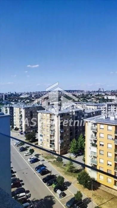 View from the terrace overlooking the urban neighborhood and a street with parking.