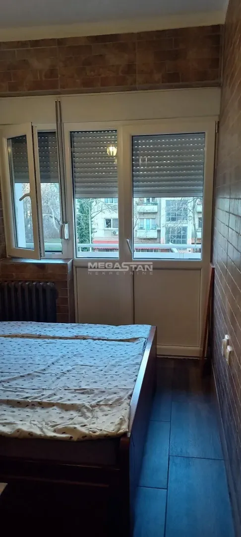 Bedroom with a bed and a window overlooking the street.