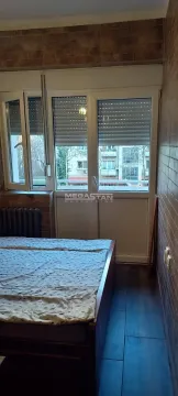 Bedroom with a bed and a window overlooking the street. - image 2