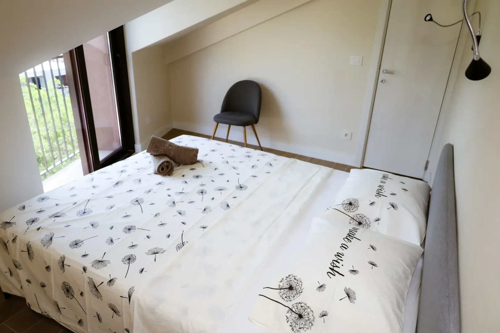 Svijetla spavaća soba sa bračnim krevetom i izlazom na terasu.