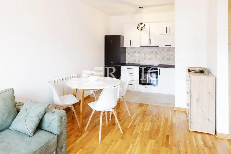 Living room with dining area and kitchen in light tones.