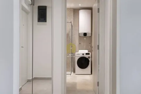 Pogled iz hodnika na moderno uređeno kupatilo sa veš mašinom. - image 10
