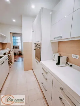 Modern kitchen with white cabinetry and built-in appliances. - image 11