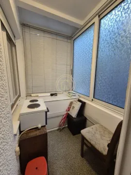 Zastakljeni balkon sa stolicom, malim šporetom i roletnama na prozorima. - image 10