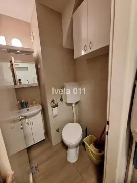 Manje kupatilo sa WC šoljom, umivaonikom i zidnim ormarićem. - image 4