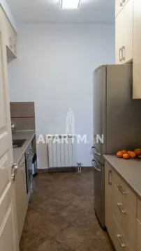 Small kitchen with light wood cabinetry and a refrigerator. - image 6