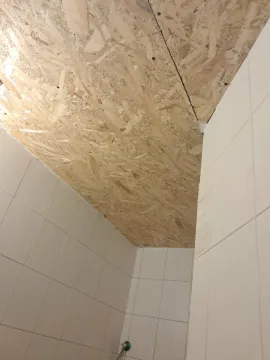 Bathroom with tiled walls and an OSB board ceiling. - image 10
