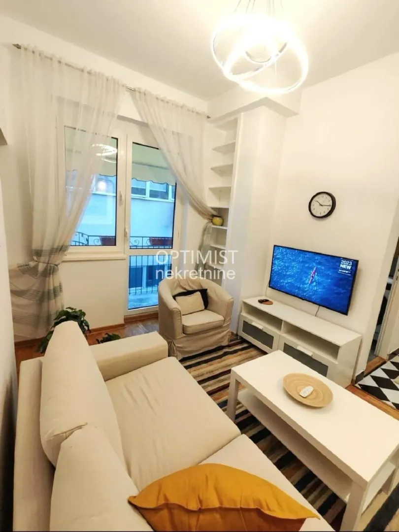 Small living room with sofa, TV and access to the terrace.