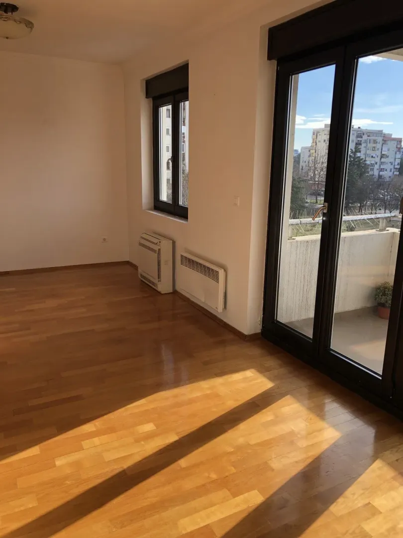 Bright empty room with balcony access.