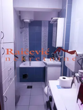 Small bathroom with a bathtub, washbasin, and blue and white tiles. - image 12