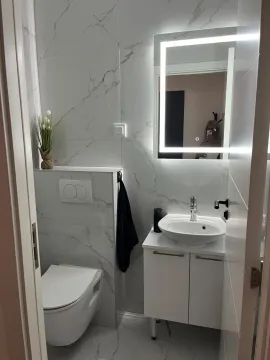 Moderno opremljeno kupatilo sa bijelim pločicama i umivaonikom sa ormarićem. - image 13