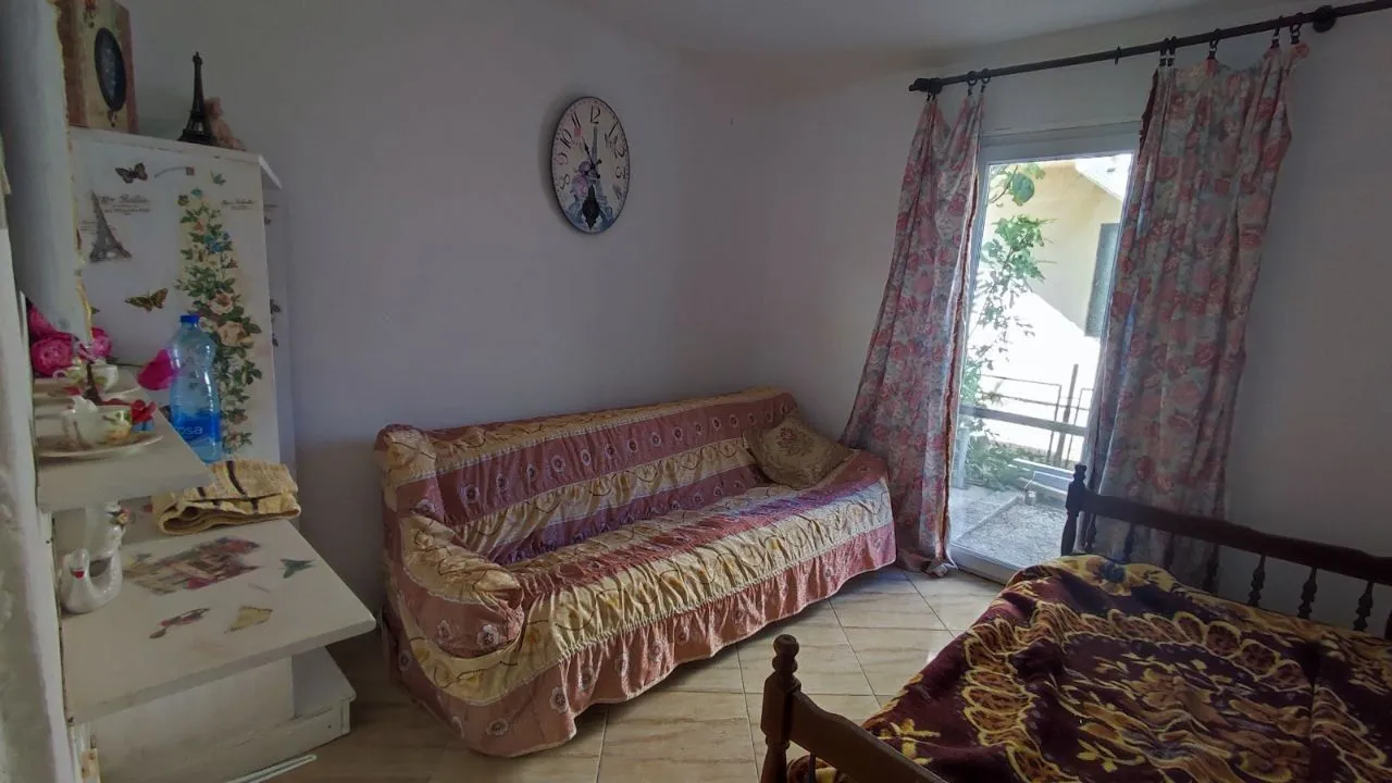 Dnevna soba sa kaučem, namještajem i izlazom na terasu.