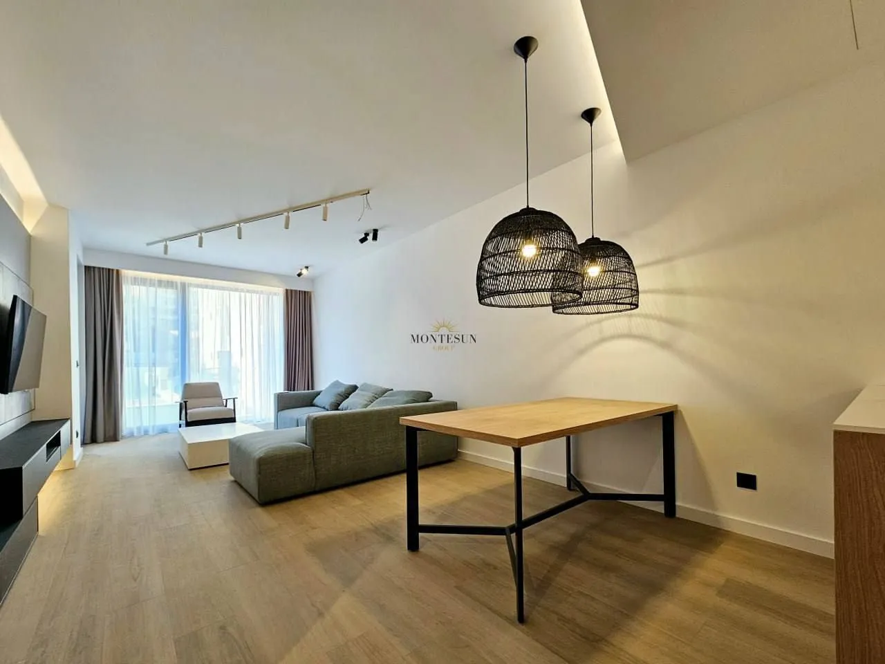 Modern living room with a dining table and recessed lighting.