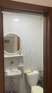 Small bathroom with a sink, mirror, and toilet, photographed through the doorway. - image 5