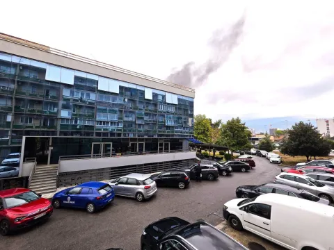 View of the exterior of the commercial building with a parking lot in front. - image 7