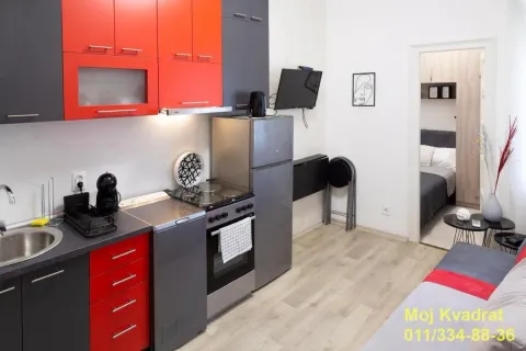 Smaller kitchen with red and gray cabinets and built-in home appliances. - image 2