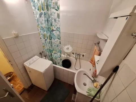 Small bathroom with a bathtub, washbasin, and washing machine. - image 12