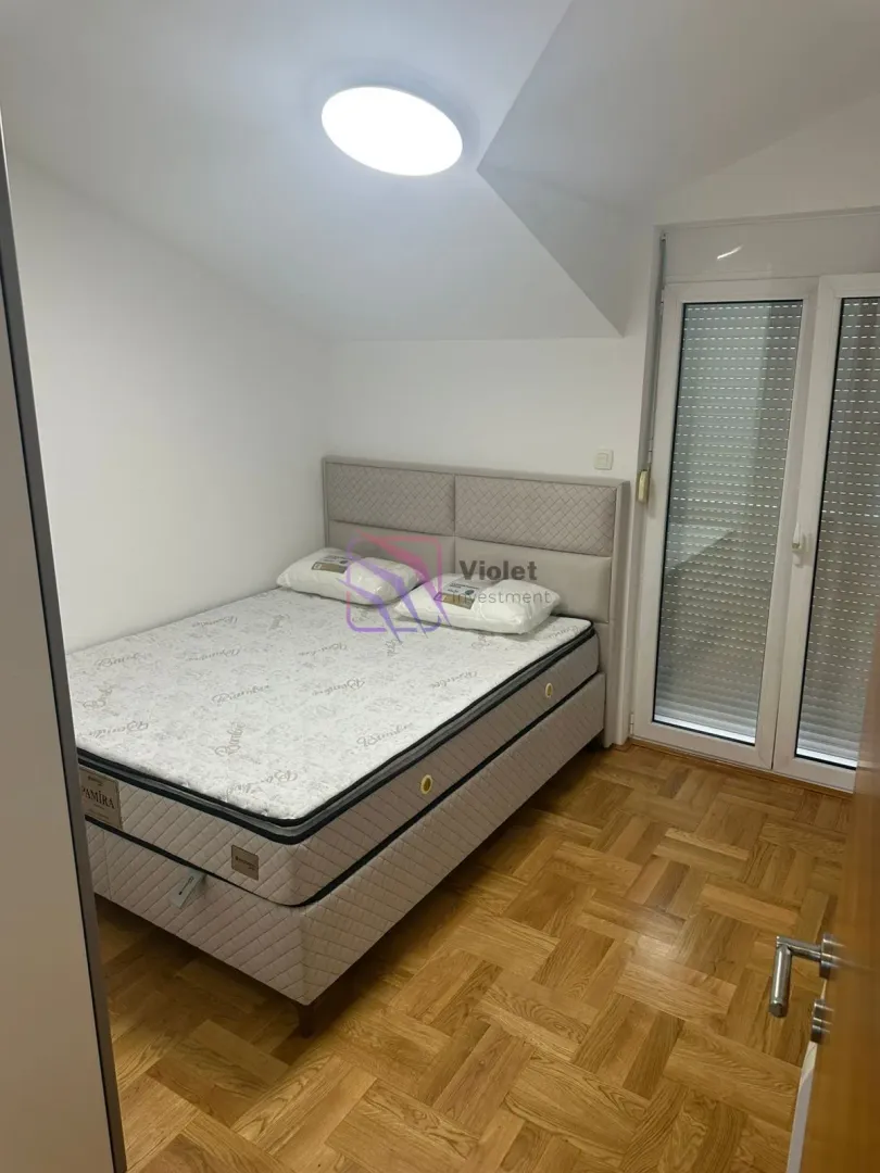 Bedroom with a double bed and parquet flooring.