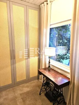 Bedroom with a large wardrobe, sewing table, and a window. - image 11