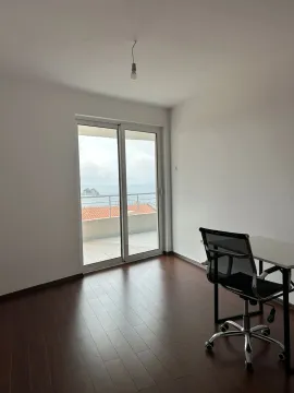 Prazna soba sa radnim stolom i stolicom i izlazom na balkon sa pogledom na more. - image 6