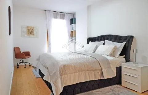Spacious bedroom with a double bed, a desk, and a white nightstand. - image 10