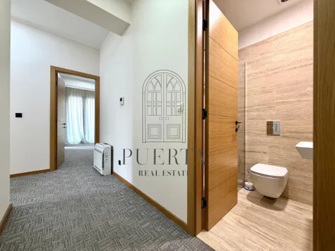 A hallway with a view of the bathroom and a room door. - image 14