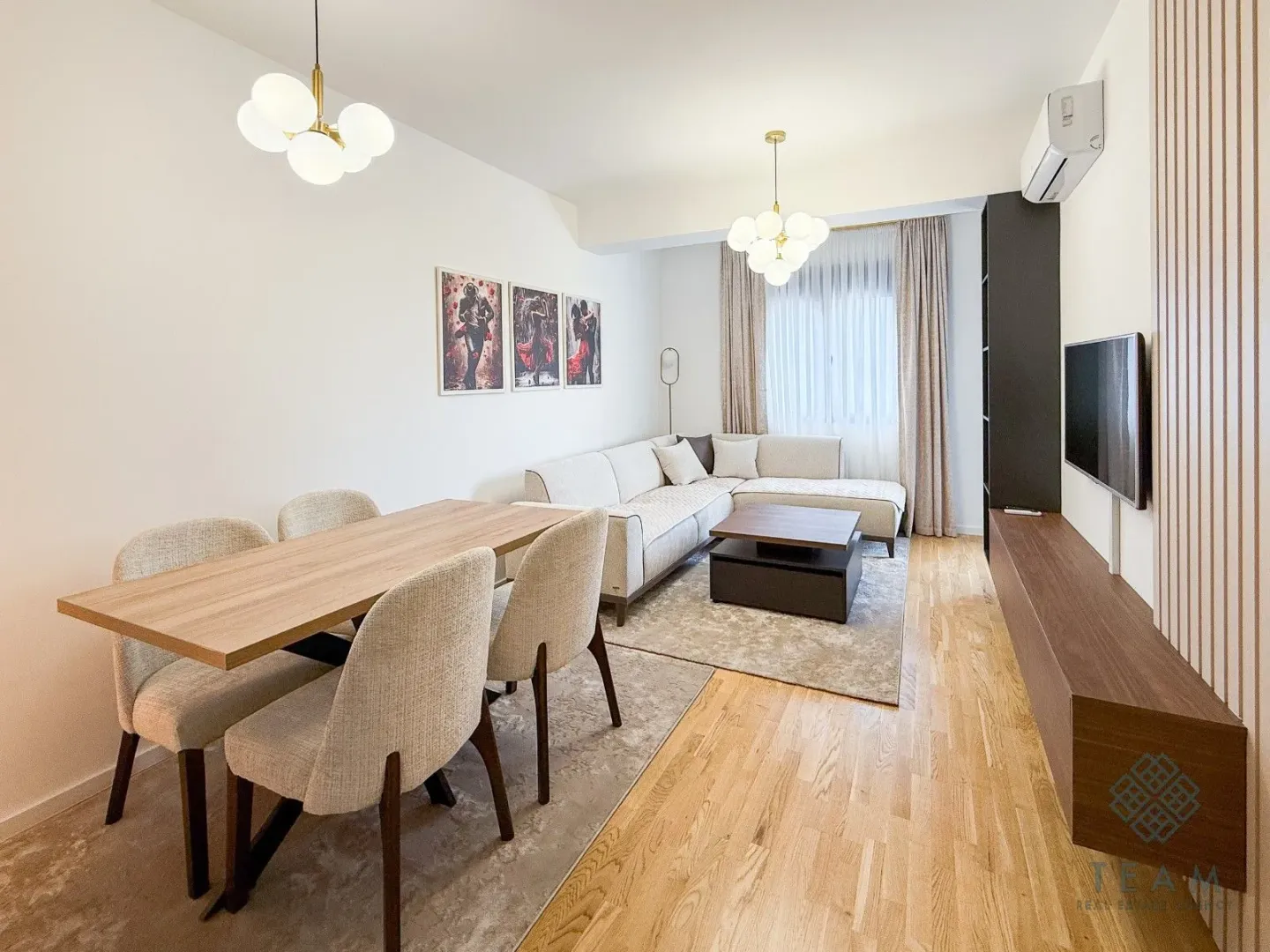 Living room with dining area, sofa set, and television.