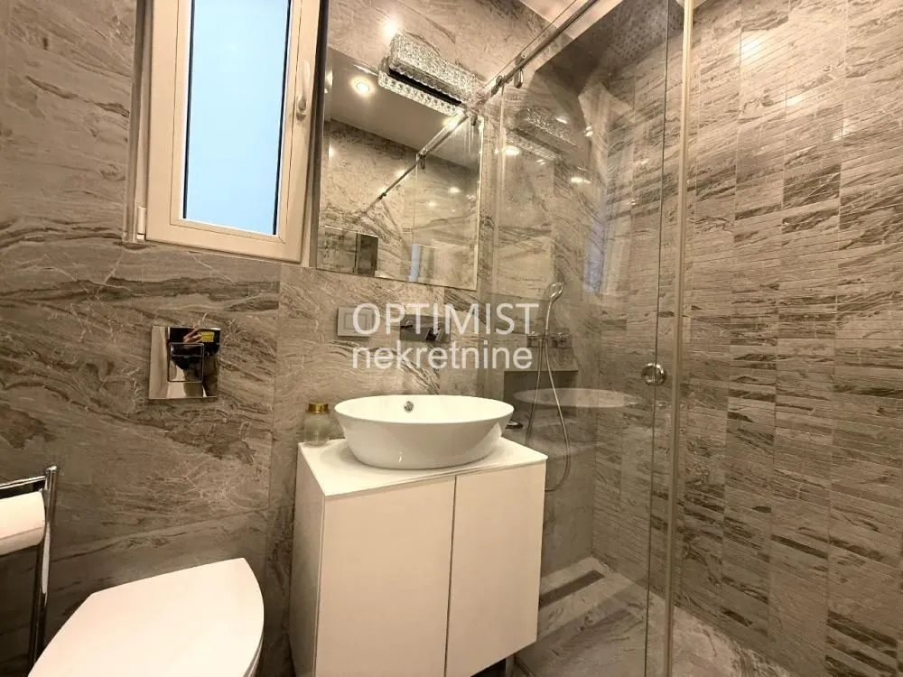 Modernly equipped bathroom with a washbasin and a shower cabin.