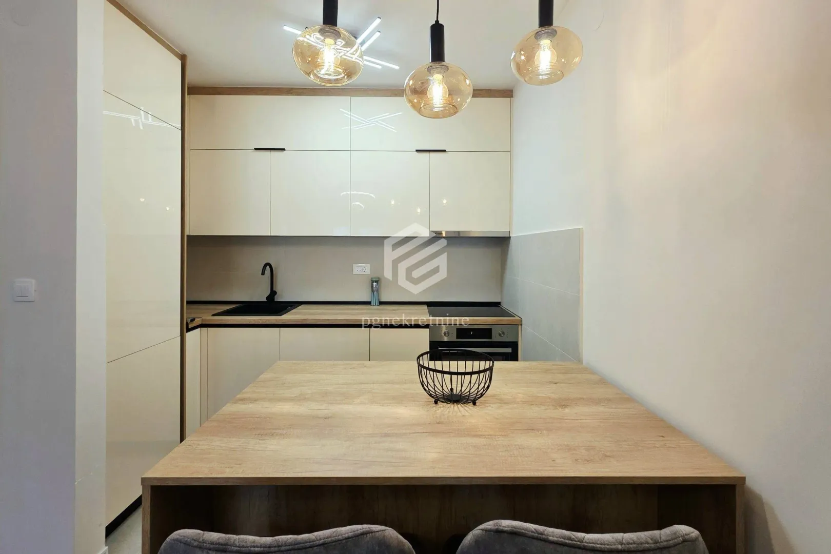 Kitchen with light-colored cabinetry and a wooden dining table.