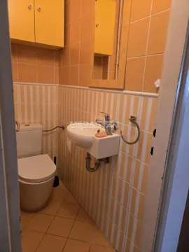 Manje kupatilo obloženo žutim pločicama sa WC šoljom i umivaonikom. - image 13