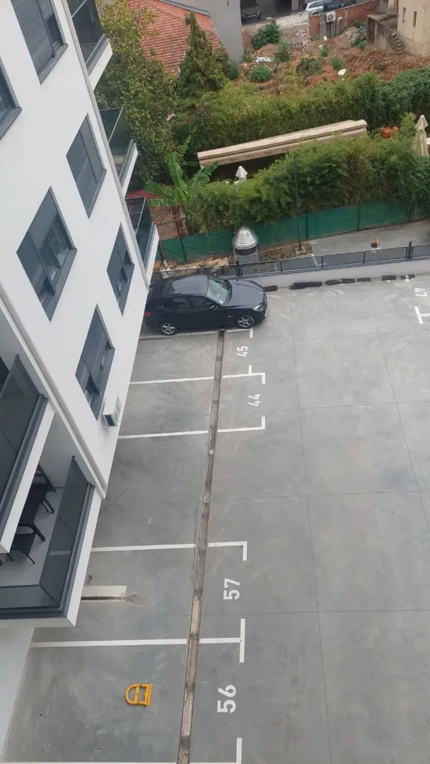 Top-down view of the parking area and part of the residential building.