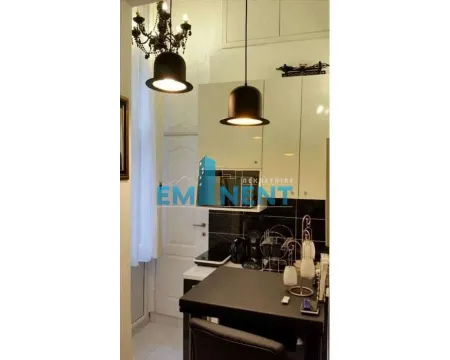 Small equipped kitchen with a dining table and modern lighting. - image 8