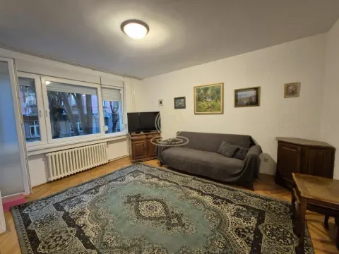 Dnevna soba sa garniturom, televizorom i velikim prozorom. - image 2
