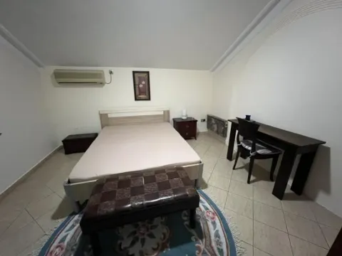 Simply furnished attic bedroom with a double bed and a desk. - image 26