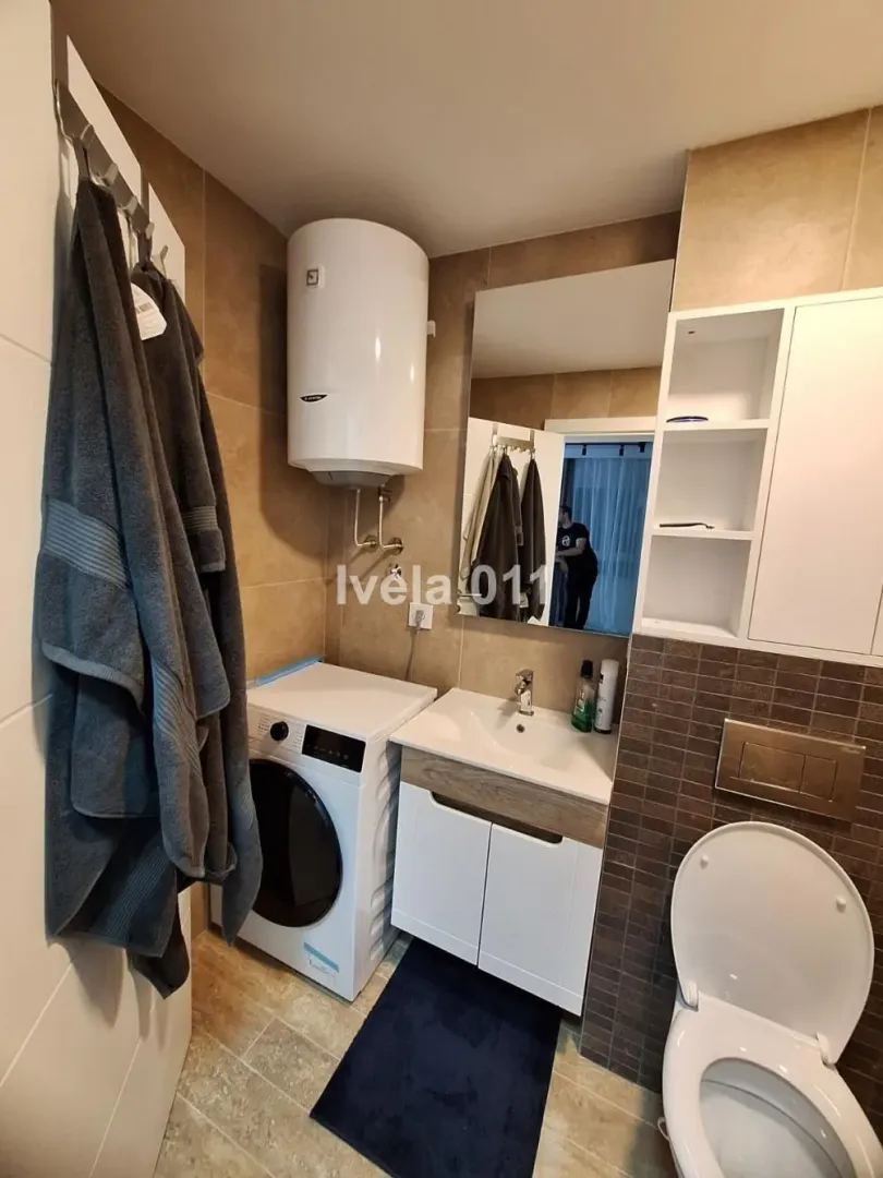 Kupatilo opremljeno umivaonikom, wc šoljom, mašinom za veš i bojlerom.